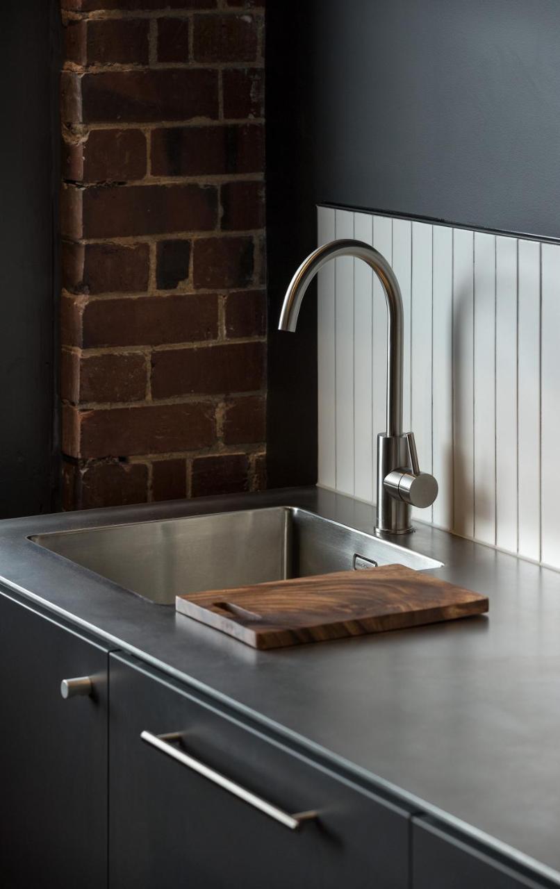 Hotel The Chamberson Dunedin Exteriér fotografie A kitchen sink with a wooden cutting board